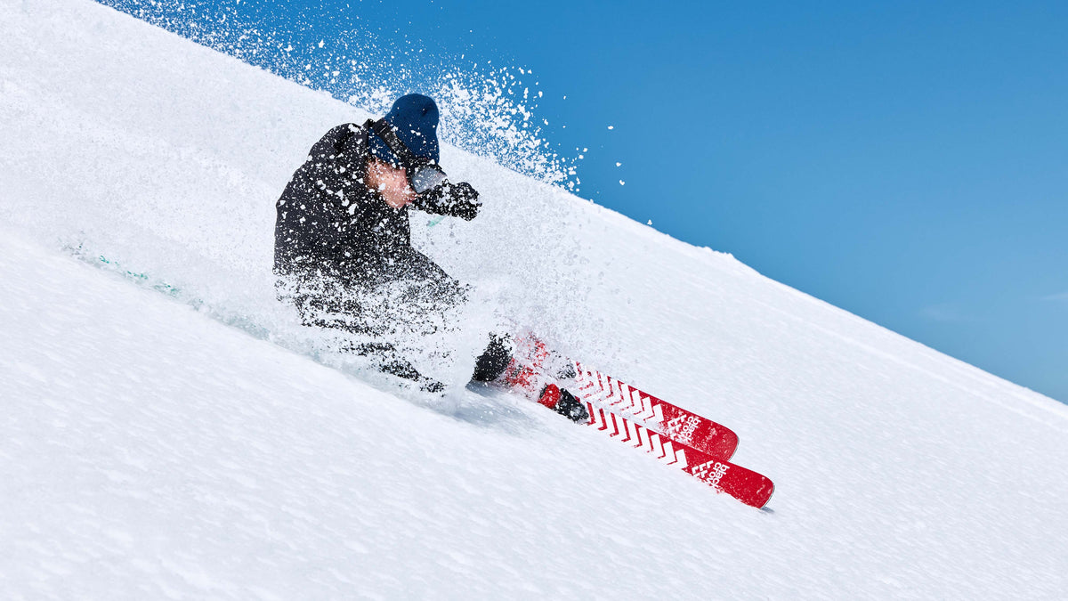 Skiër carvet door de sneeuw op de Black Crows Camox