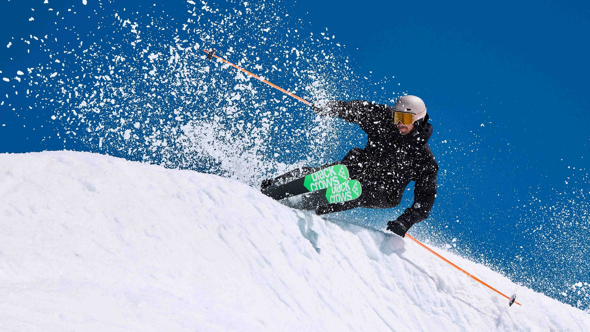 Skiër in een bocht door stuivende sneeuw op de Black Crows Captis