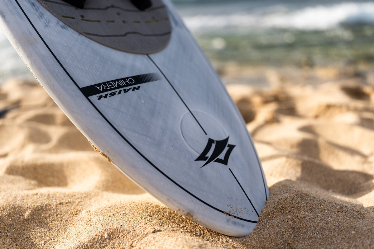Neus van het Naish Chimera wingfoilboard op het strand