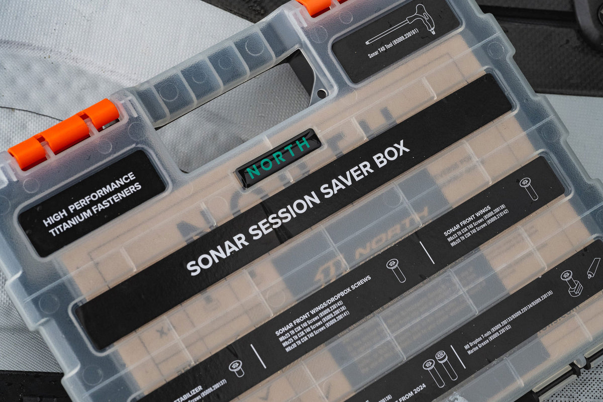 Close-up van de gesloten North Sonar Session Saver Box met titanium schroeven op een foilboard