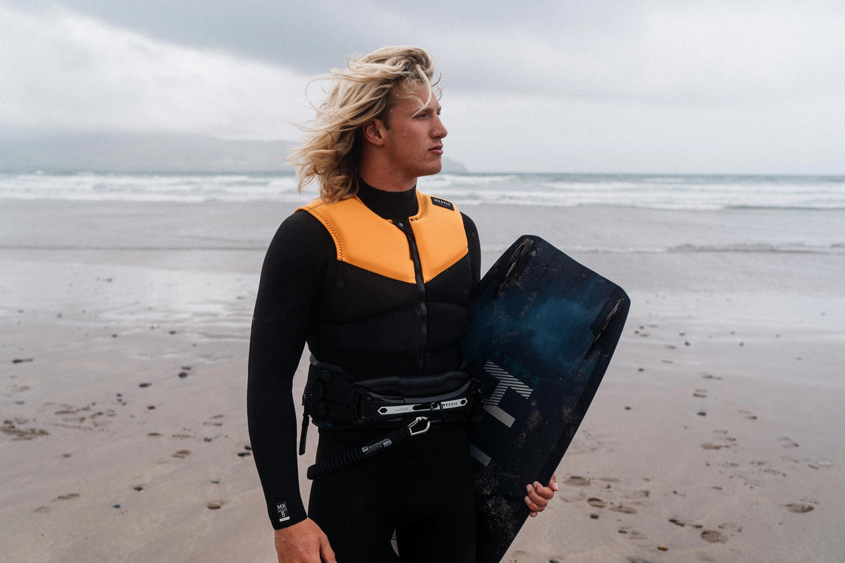 Kiter met de Mystic Block Impact Vest en trapeze op het strand