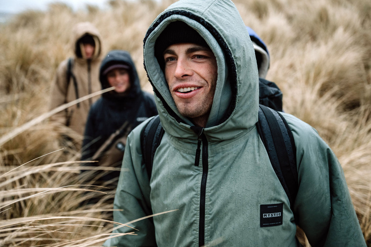 Mystic Poncho Explore met capuchon op, in de duinen