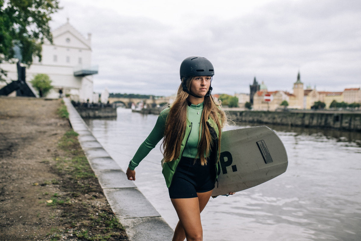 Wakeboardster met de Mystic Star Impact Vest Fzip Wake Women langs het water