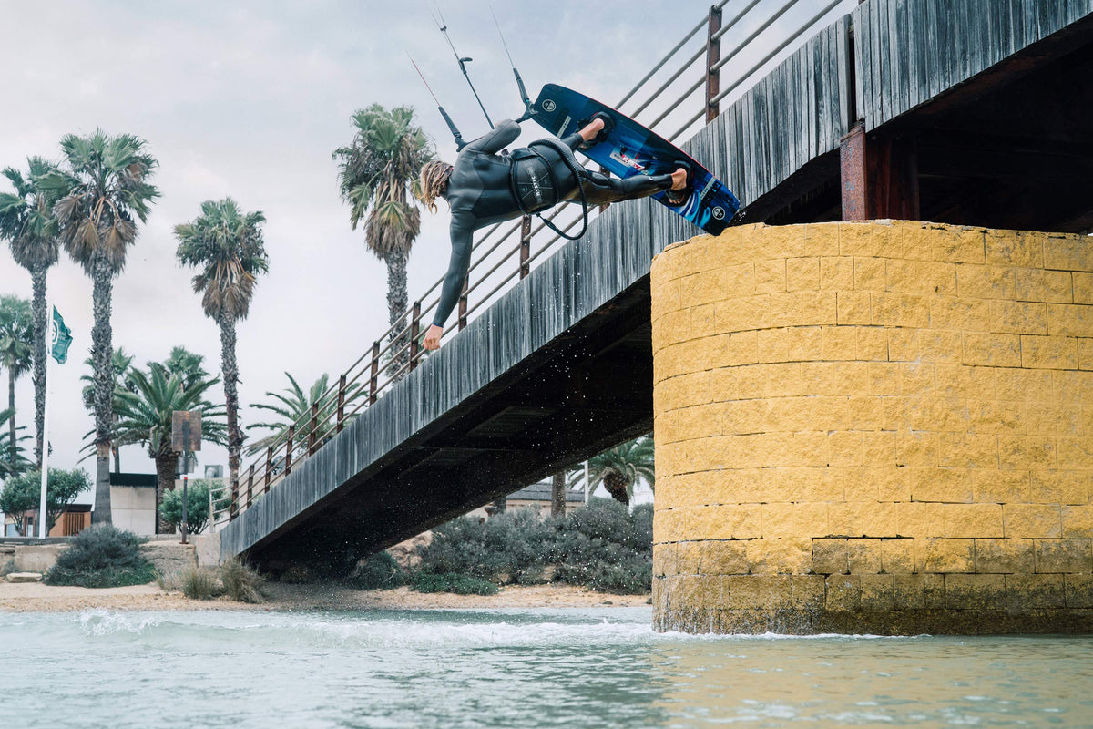 Kiter in een Mystic Motion Fullsuit springt bij een brug