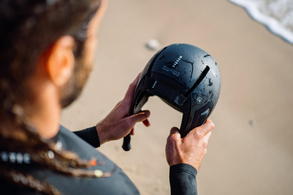 Mystic Legacy Helmet in de hand op het strand