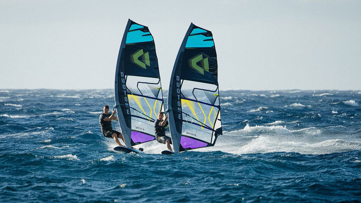Twee windsurfers naast elkaar op de Duotone Warp Fin 2027 in harde wind