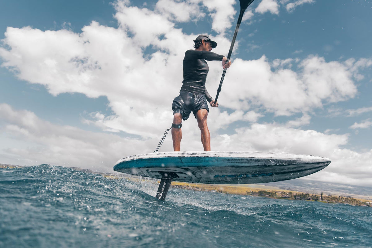Peddelen op de foil met de Naish Hover DW NVision 2025 op open water bij Maui