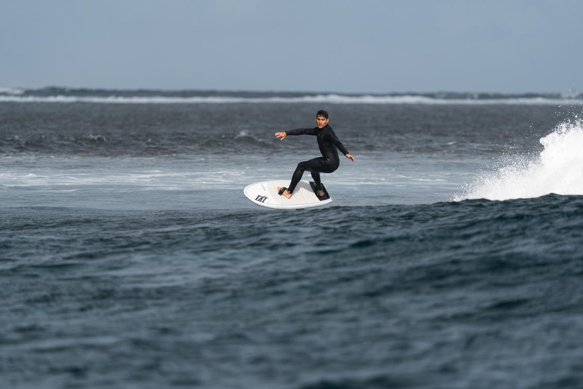 Rider op de golf met het Naish Hover Wing Ascend Carbon Ultra wingfoilboard