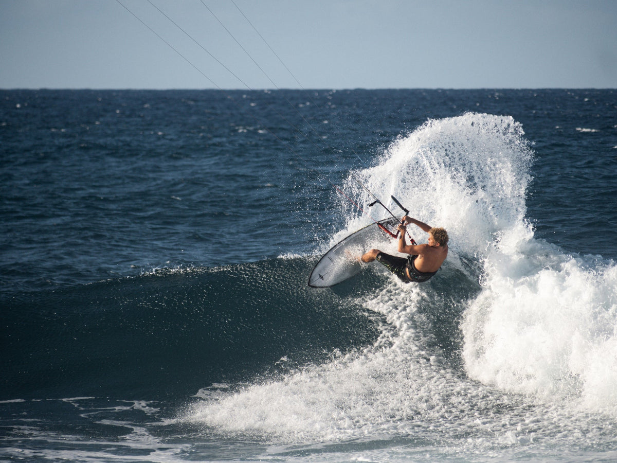 Kitesurfer maakt een top turn op de Naish Kokomo 2025 in een golf bij Maui