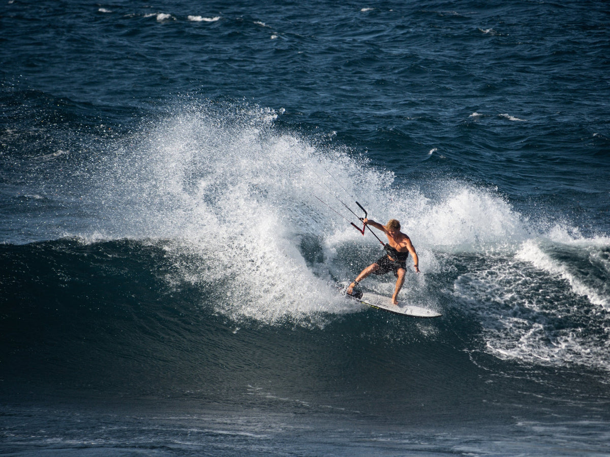 Bottom turn op de Naish Kokomo 2025 onder een brekende golf bij Maui