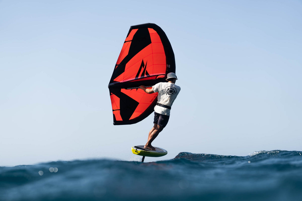 Naish Neutron wingfoil wing op de foil boven de swell