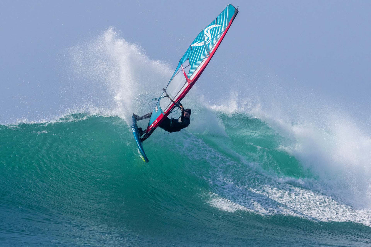 Windsurfer met de Simmer Style Blacktip 2025 in een aerial op de lip van een golf