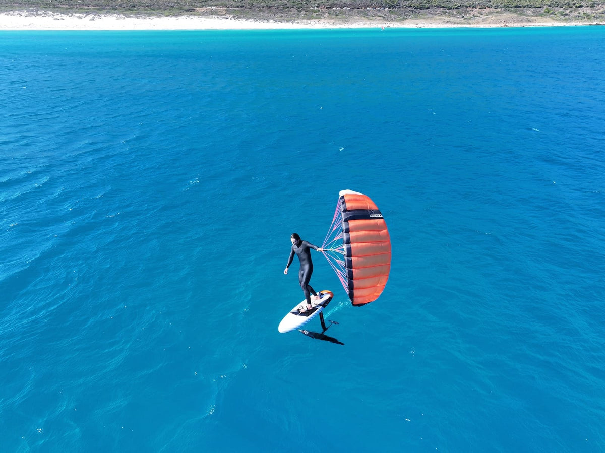 Foiler vaart met de RRD Pocket Wing over blauw water voor de kust