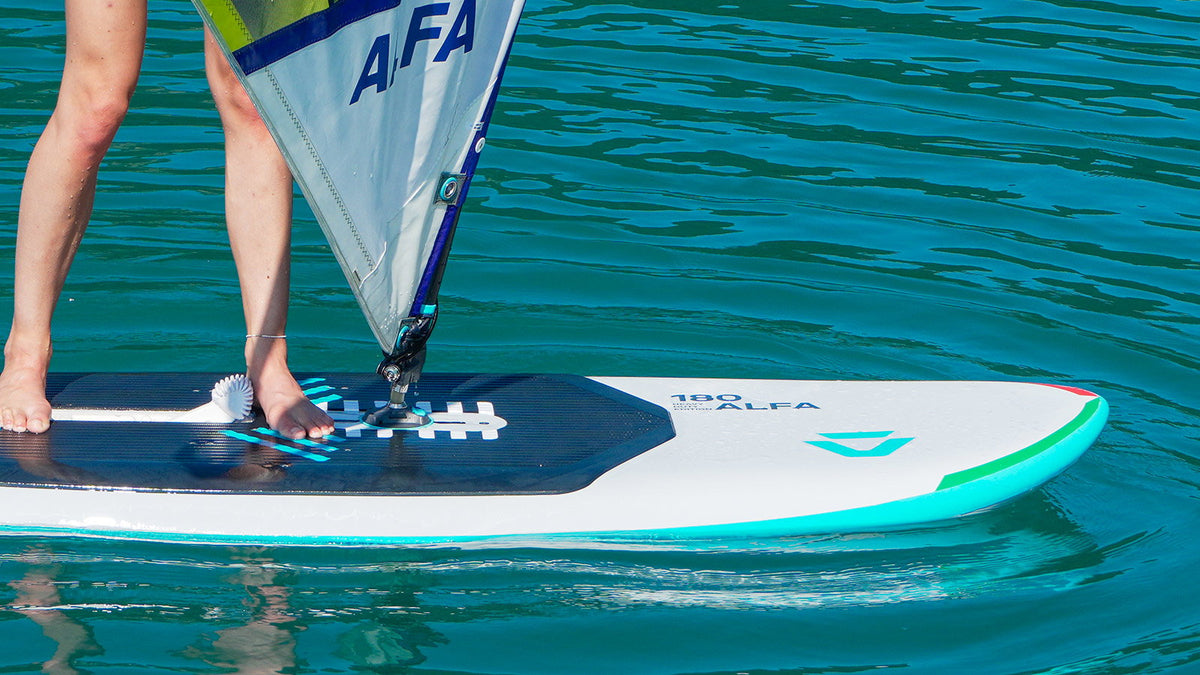 Duotone Alfa HD 180 in wit en turquoise tijdens het windsurfen op kalm water