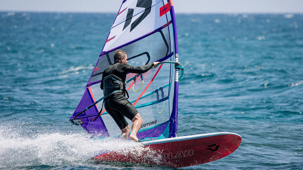 Windsurfer in volle vaart op zee op de Duotone Blitz D/LAB met rode D/LAB-onderkant