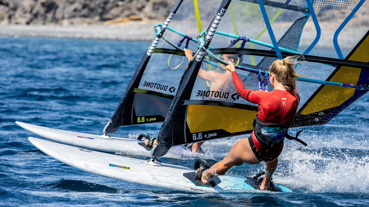 Twee windsurfers naast elkaar op de Duotone Eagle D/LAB langs een rotskust