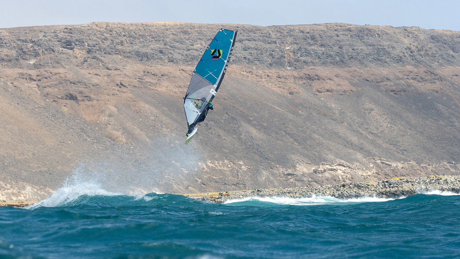 Duotone Super_Hero D/LAB 2026 wave riding aan rotsachtige kust