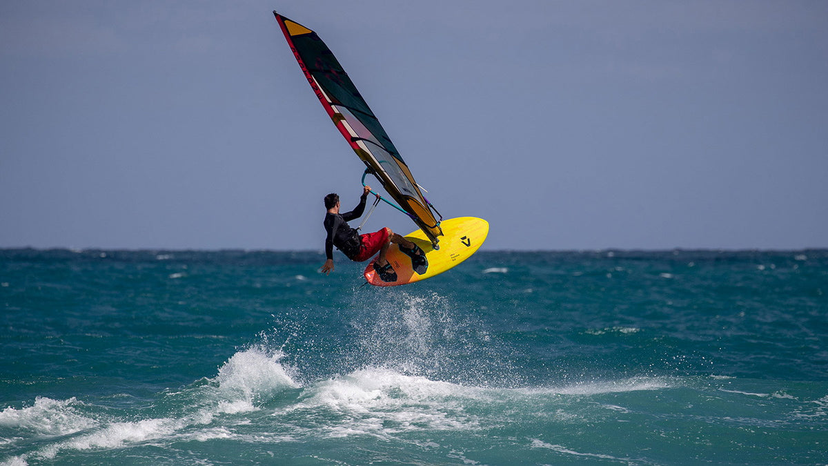 Windsurfer springt met de gele Duotone Ultra FreeWave SLS boven zee