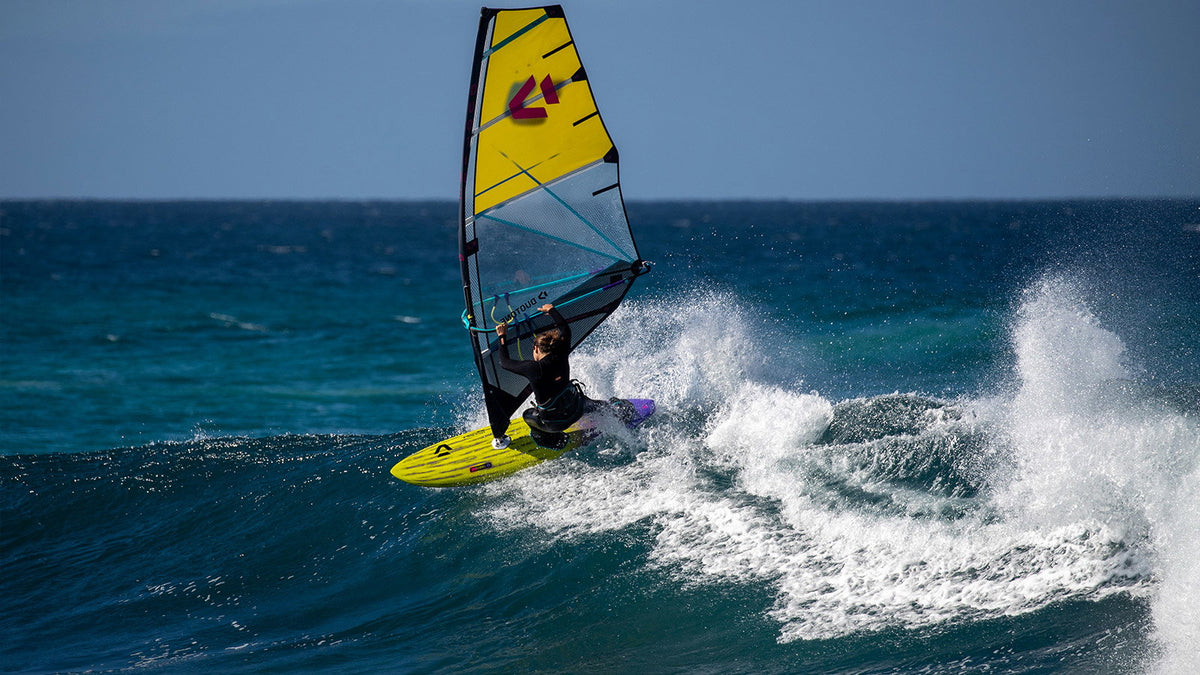 Duotone Ultra Grip (Quad) SLS windsurfboard in een bocht op de golf in de oceaan