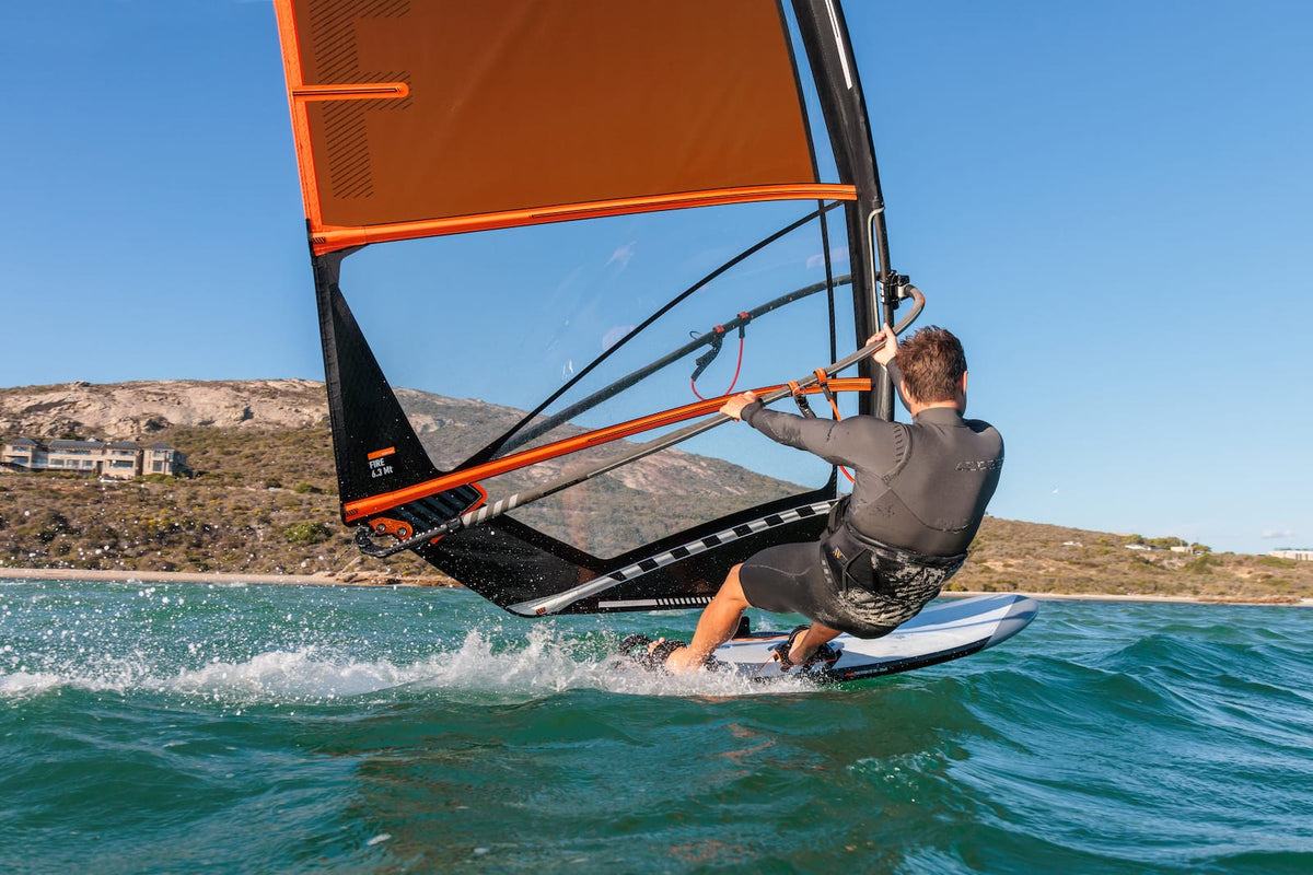 Planeren in de footstraps op de RRD Firestorm LTE Y28 langs een heuvelachtige kust