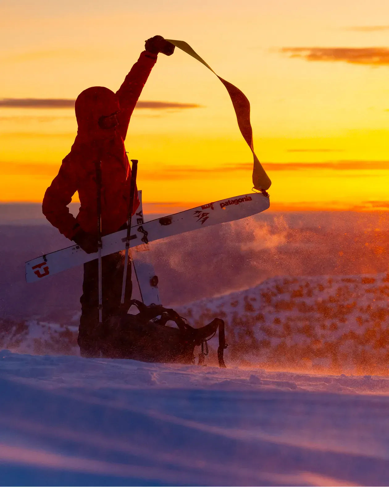 Jones Ultralight Hovercraft 2.0 Splitboard, splitboarder houdt het board omhoog bij zonsondergang