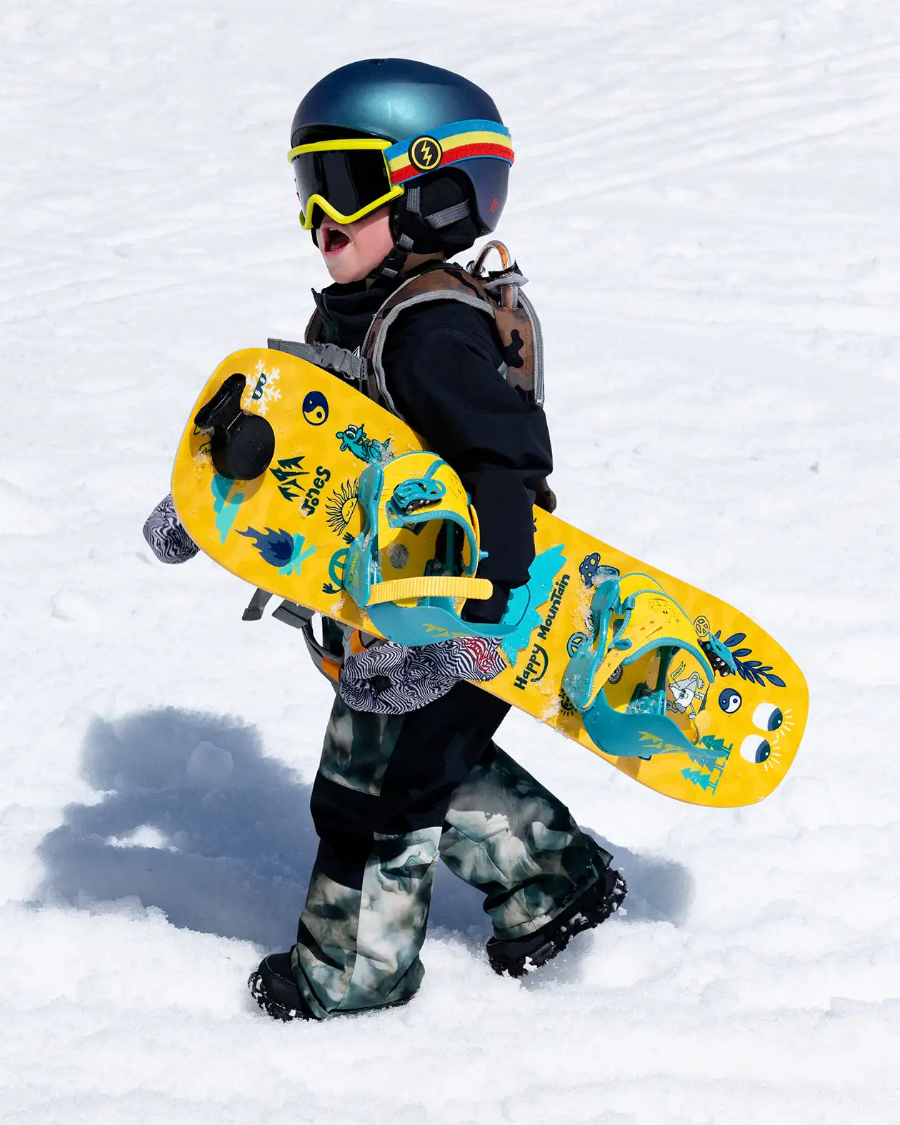 Jones Kids' Happy Mountain Package, kind draagt het board in de sneeuw