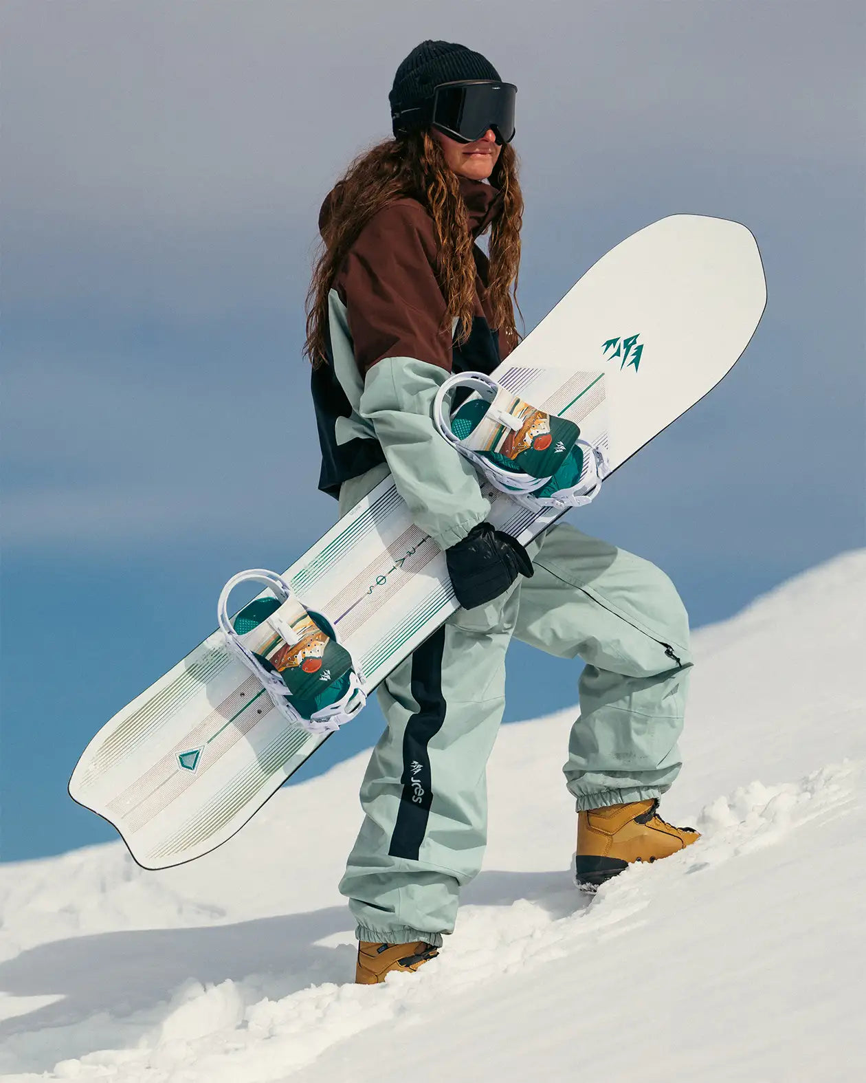 Jones Women's Stratos, rider met het board in de hand in de sneeuw