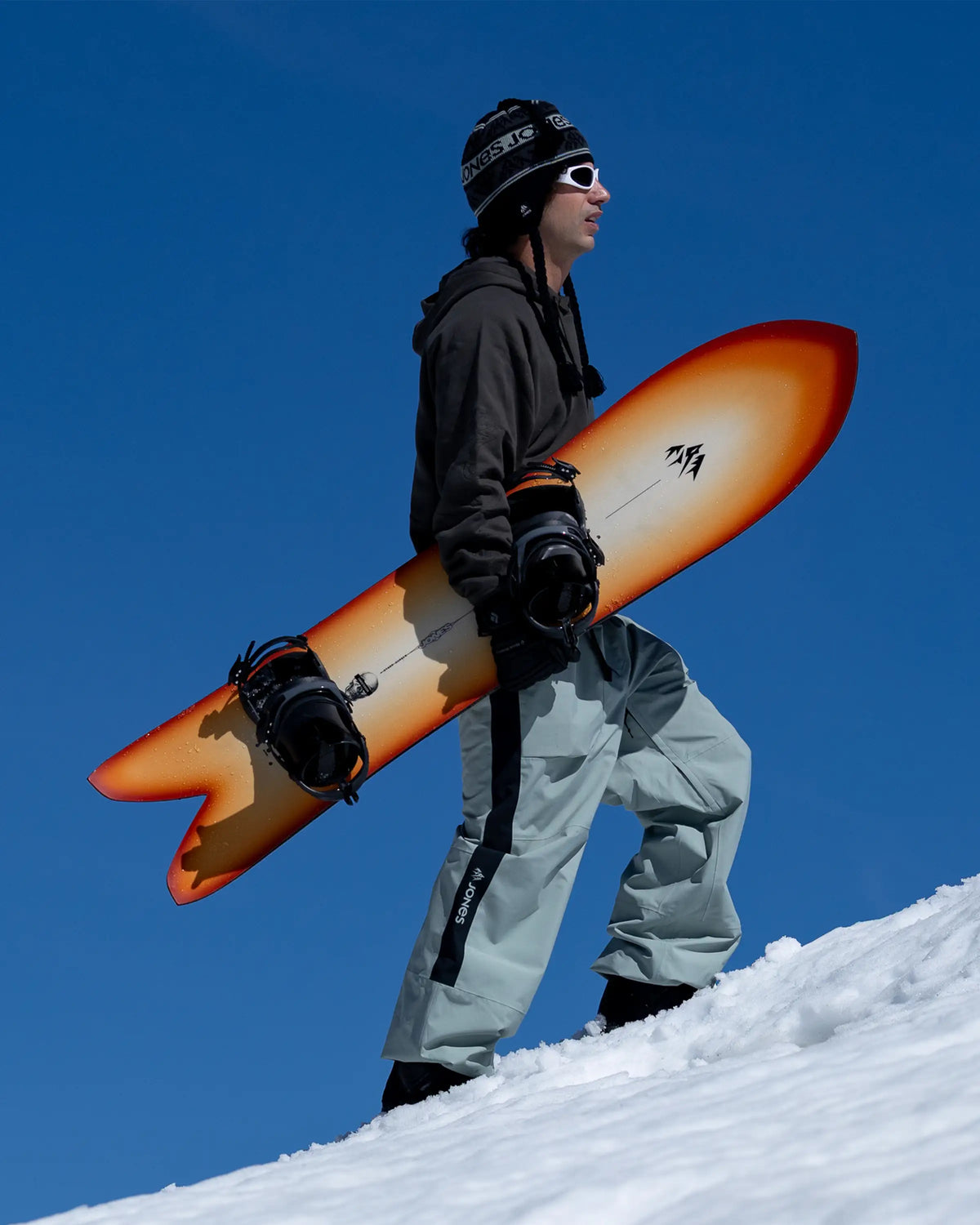 Jones Storm Chaser, rider met het board in de hand in de sneeuw