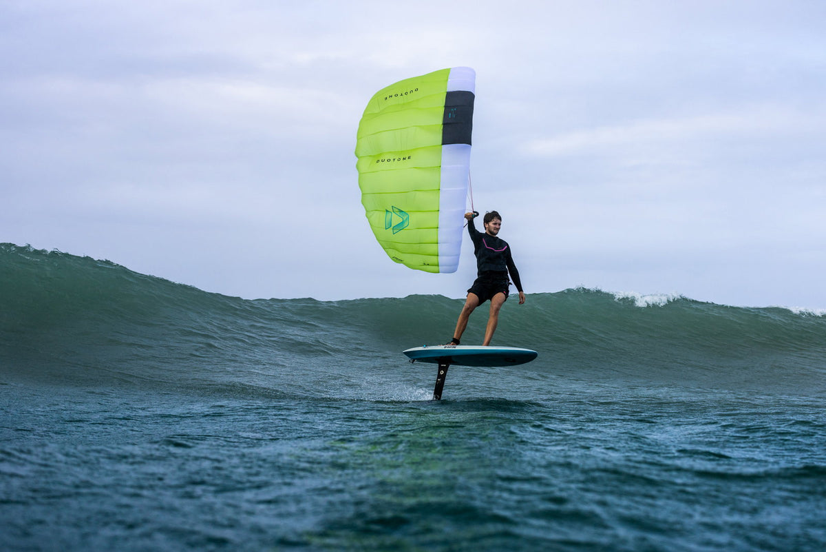 Rider foilt met de lime Duotone Stash parawing voor een golf