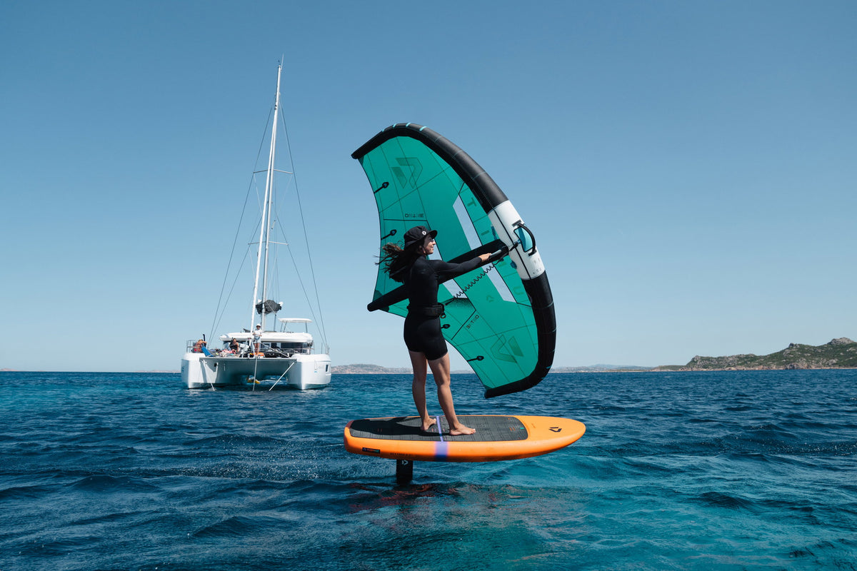Rider foilt op de Duotone Sky Free met een catamaran op de achtergrond