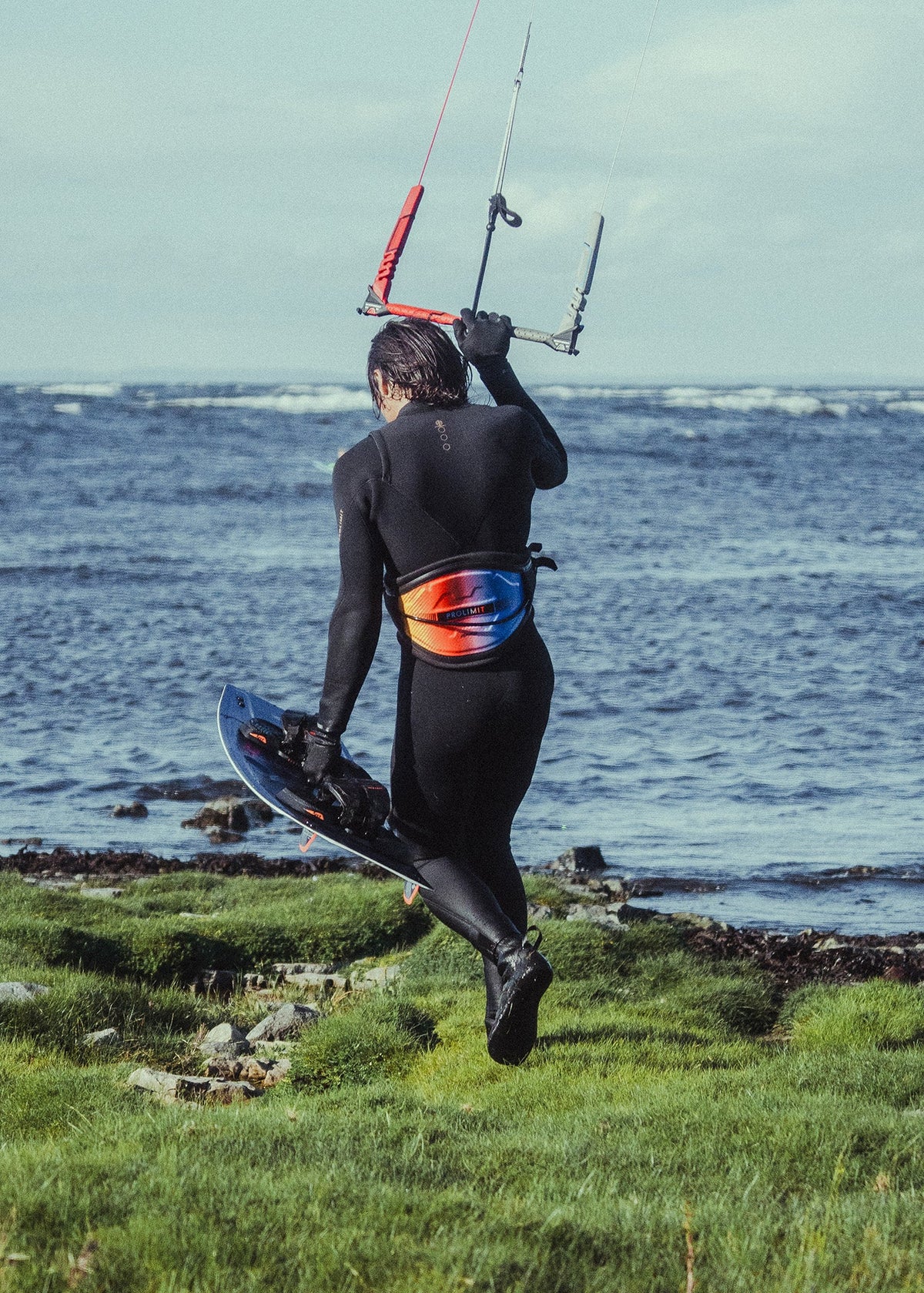Kitesurfer in de Prolimit PF3 Steamer Free-X loopt met board de zee in