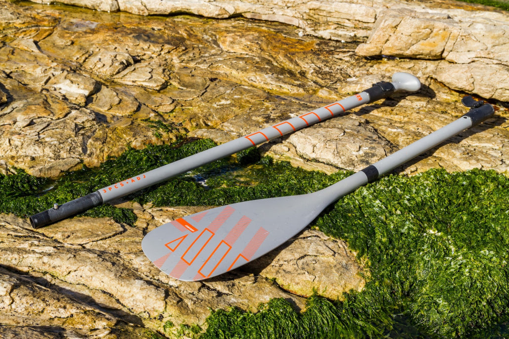 RRD Flow SUP-peddel met blad en verstelbare steel op de rotsen
