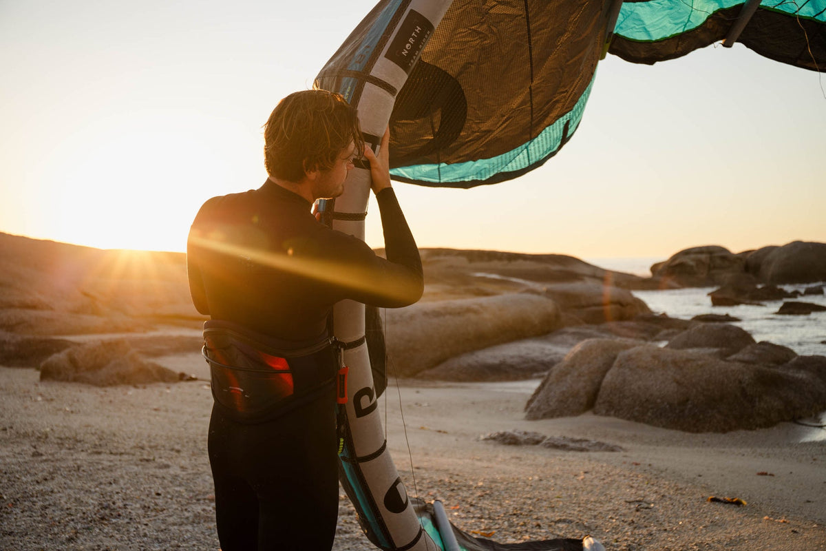 Kitesurfer in de Prolimit Predator Steamer 3/4 Freezip met kite op het strand
