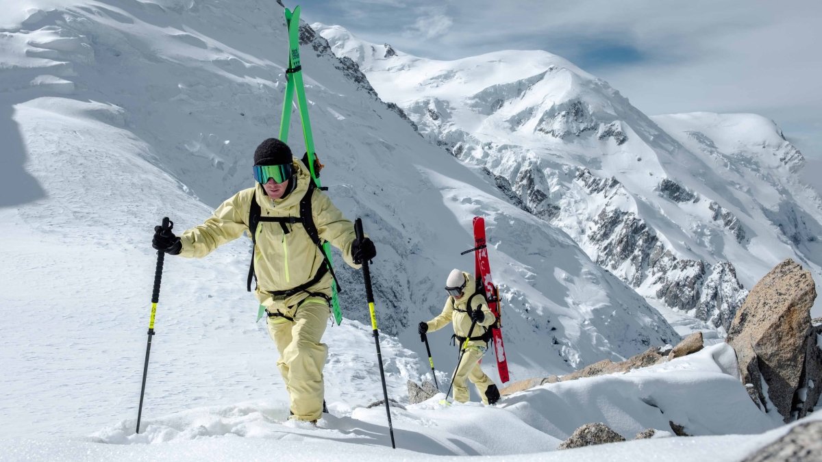 Black Crows Duos Freebird Poles, twee tourskiërs lopen met de stokken omhoog in het hooggebergte
