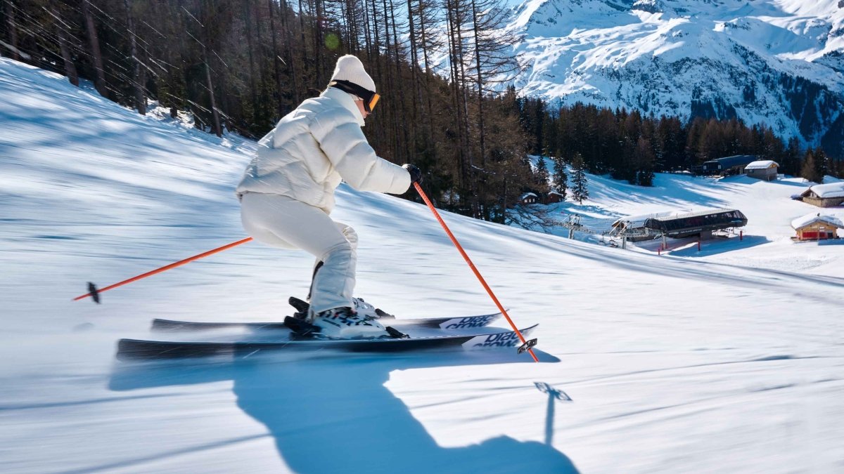 Black Crows Meta Poles oranje, skiër maakt een bocht op de piste met de stokken in de hand