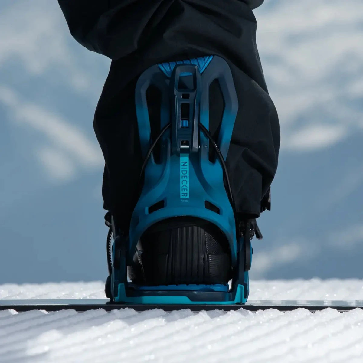 Flow Fenix Cyber Blue, binding met boot op een snowboard in de sneeuw