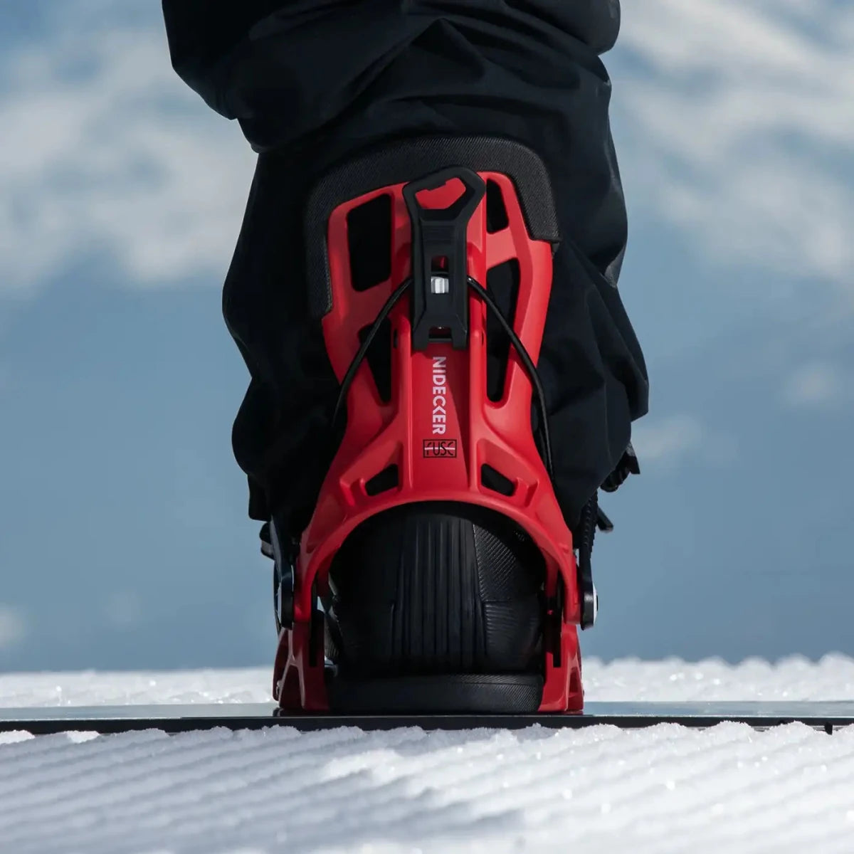 Flow Fuse Cherry, binding met boot op een snowboard in de sneeuw