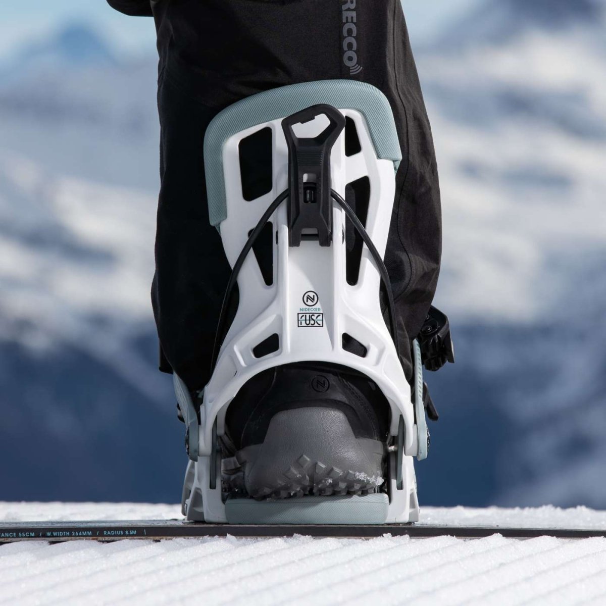 Flow Fuse White, binding met boot op een snowboard in de sneeuw
