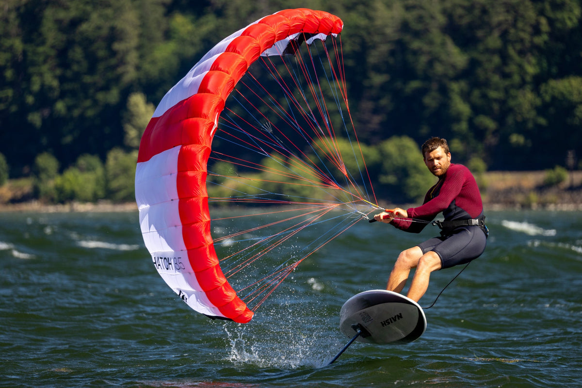 Rider met de Naish Hatch V2 parawing laag boven het water
