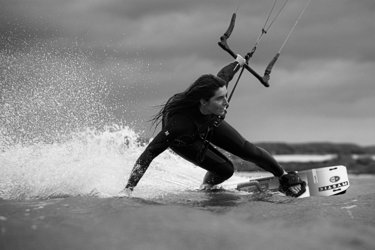 Kitesurfster in de Mystic Jayde Fullsuit in een bocht, zwart-wit
