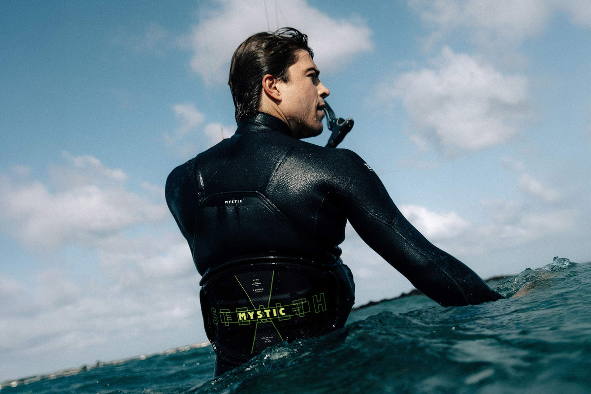 Kitesurfer in de Mystic Majestic Fullsuit tot zijn middel in het water
