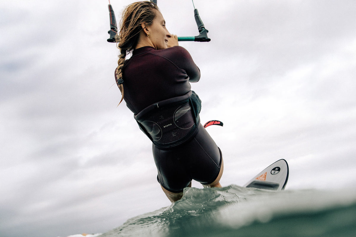 Kitesurfster in de Mystic Lunar Longarm Shorty 2/2mm Fzip Women aan de bar