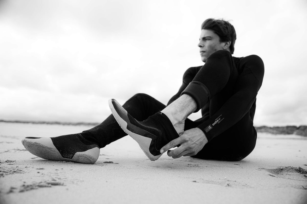 Rider trekt Mystic Supreme-boots aan op het strand