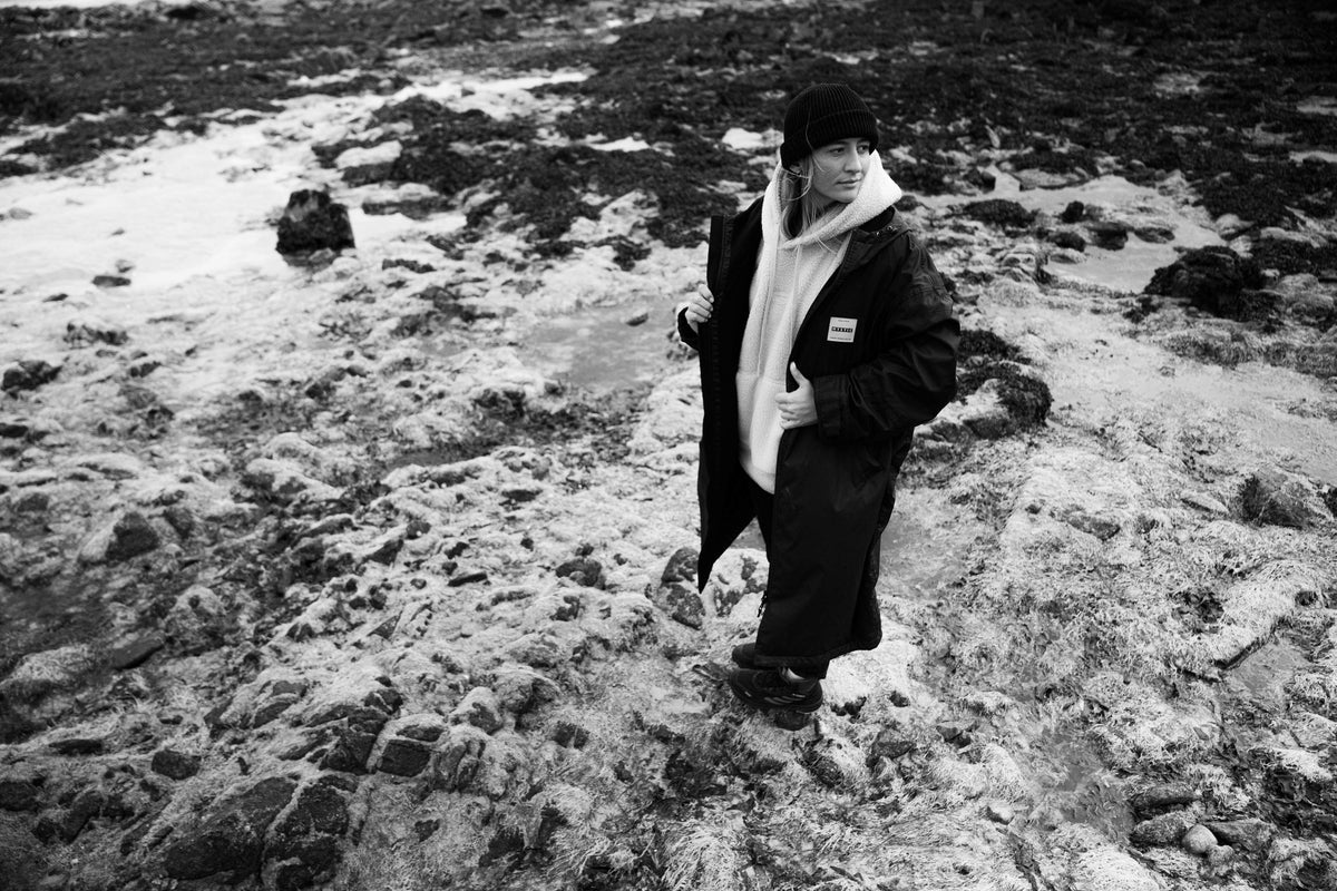 Mystic Poncho Explore LW gedragen op de rotsen bij laagwater