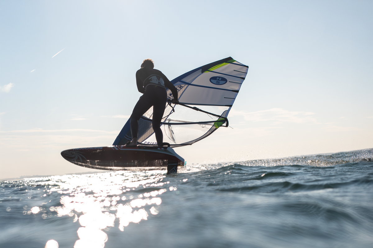 North Prisma Foil in tegenlicht, windfoiler boven glinsterend water