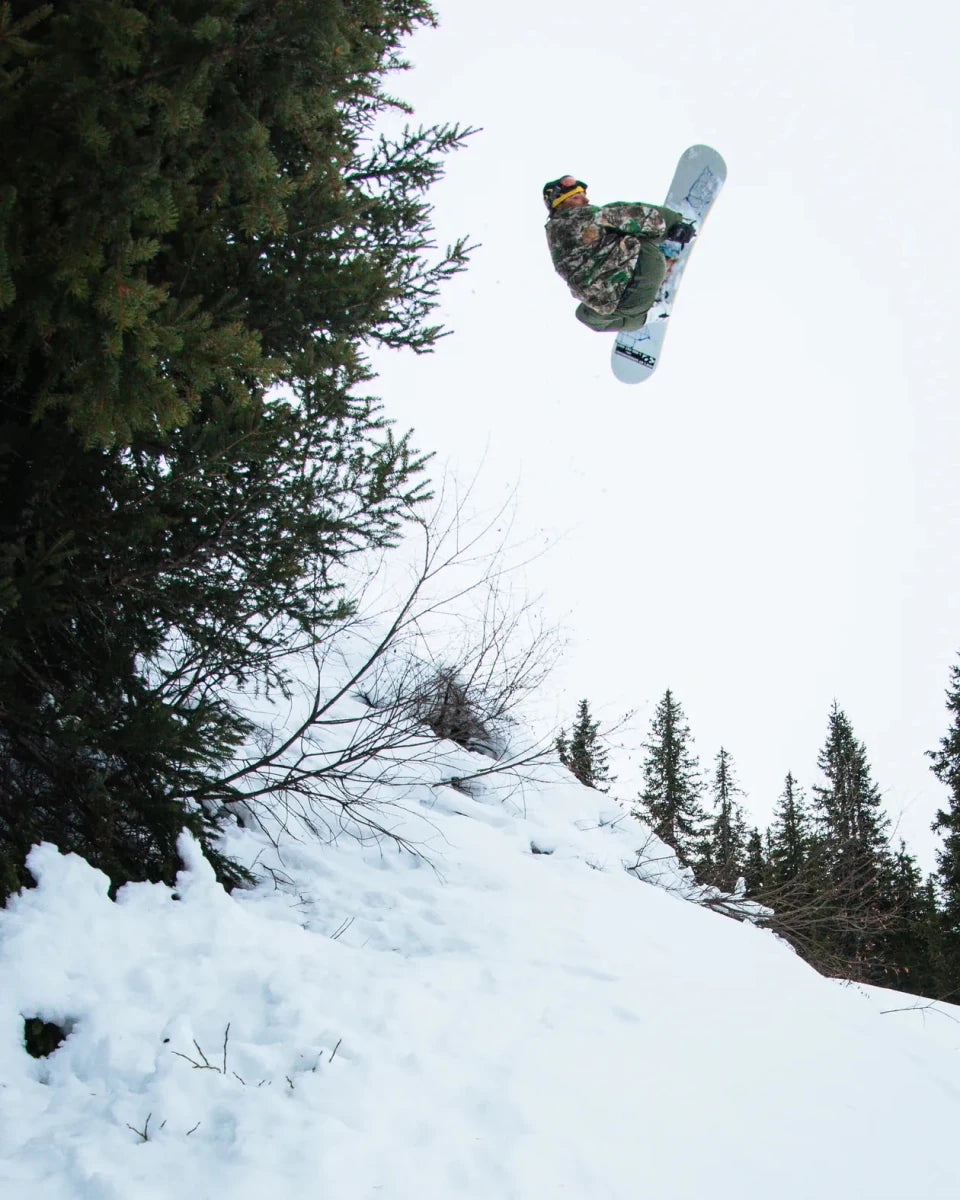 ThirtyTwo XXX Fava Pro wit-groen, rider in de lucht boven de sneeuw